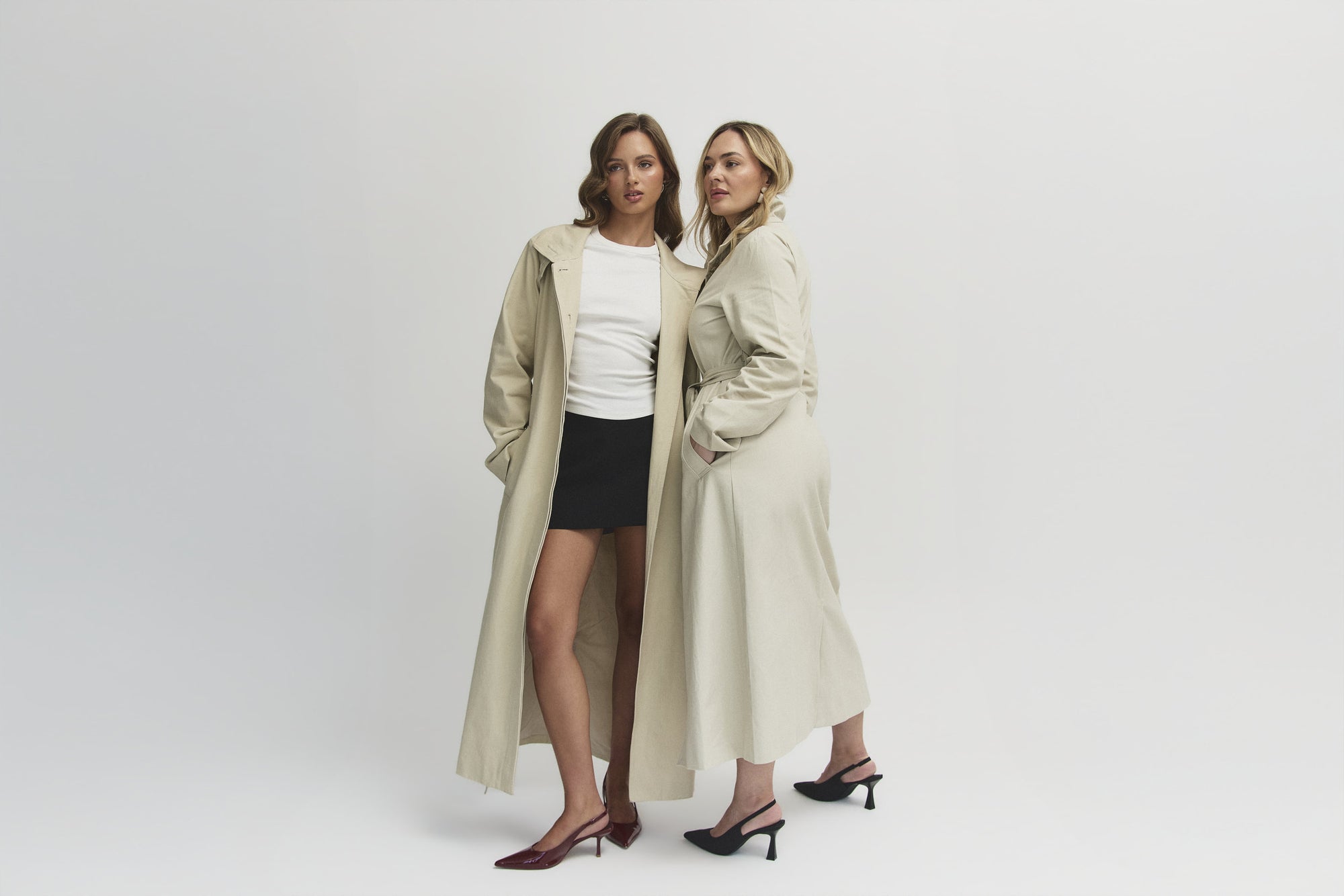 Two models wearing the Capsule Original Trench, full length studio shot